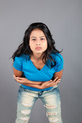 A young woman confidently poses wearing blue t-shirt, distressed denim jeans, heels, showcasing a casual urban style with charm and elegance, suitable for haircare, freedom, self-expression project