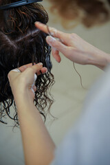 Natural curls, wavy hair care with special mousse in beauty salon. CGM, curly girl method from professional hairdresser