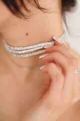 close up of a young woman holding a necklace