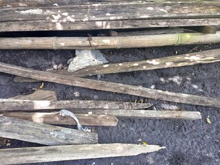 Discarded Weathered Wood Planks and Bamboo on Dark Ground