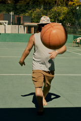 Middle-aged caucasian man playing basketball alone in the hotel of Turkey.