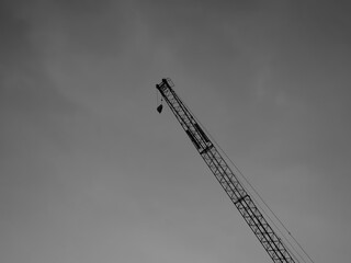 クレーンと曇り空。モノクロ。