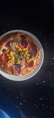 a closeup shot of a delicious pizza with a slice of tomato and a slice of pizza on a plate