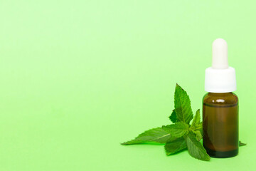 Natural Mint Essential Oil in a Glass Bottle. organic cosmetics with herbal extracts of mint on...