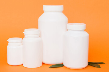 supplement pills with medicine bottle health care and medical top view. Vitamin tablets. Top view mockup bottle for pills and vitamins with green leaves, natural organic bio supplement, copy space