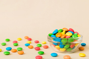 Multicolored candies in a bowl on a colored background. birthday and holiday concept. Top view with copy space
