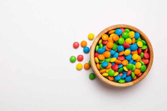 Multicolored candies in a bowl on a colored background. birthday and holiday concept. Top view with copy space
