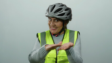 Hispanic senior woman wearing a helmet and reflective vest smiling with isolated white background, making gestures implying spending money.
