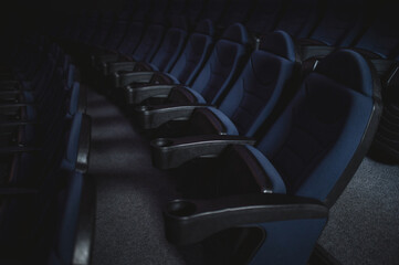 rows of blue comfortable chairs in a cinema hall in the dark, noisy dark photo