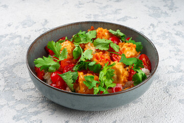 Vegetarian poke with rice and eggplant in a bowl on a concrete table.
