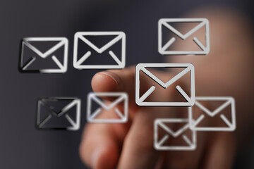 Person interacting with email icons, digital communication concept.