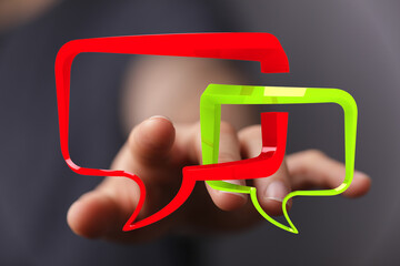 Abstract image of a hand interacting with colorful speech bubbles, symbolizing communication and...