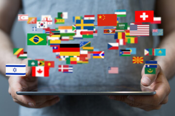Person holding tablet displaying numerous flags, representing international communication and...