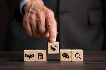 Businessperson placing handshake icon block representing agreement deal partnership and success concept
