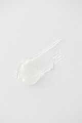Transparent clear facial cleanser gel texture smear on white background, minimal clean skincare product concept