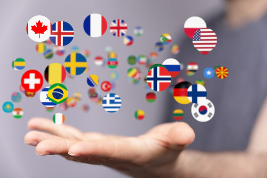 Stock photo of a hand holding various country flags, representing global communication and international relations.