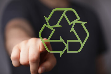 Hand pointing at a recycling symbol. Eco-friendly, sustainability concept.  Perfect for...