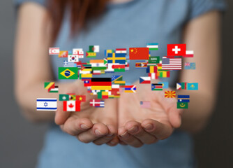 Image of hands holding a diverse array of flags, symbolizing global unity and international...