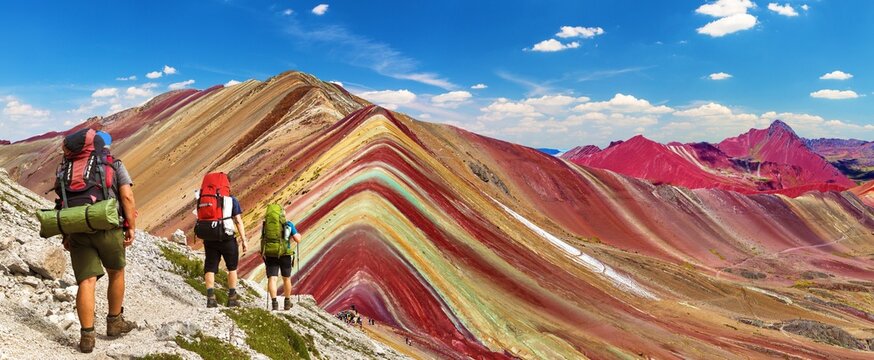 Rainbow mountains with three tourists or hikers