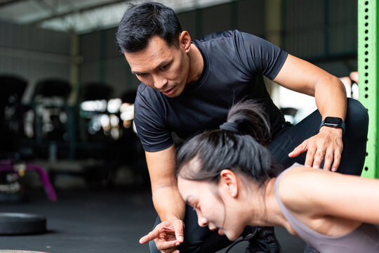 Personal Training Session. Fitness coach guiding a woman during a workout in a gym. - Powered by Adobe
