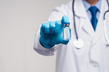 Doctor in gloves holding clear vaccine vial, concept of immunization, health care, and prevention.