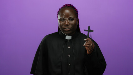 Woman priest holding cross against vibrant purple background, smiling confidently in religious...