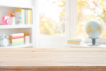 Empty wood table top on blurred background of classroom interior with book shelf and window sill. Original work - no AI used
