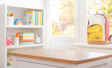 Blank school table in front of blurred shelf with multicolor supplies and backpack on window sill background. Original work - no AI used