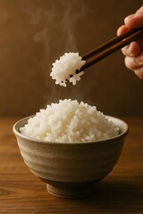 お茶碗に盛られた湯気が立ち上る白米を箸で持ち上げるシーン