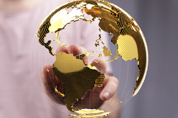 High-quality stock photo of a hand interacting with a golden globe, representing global...