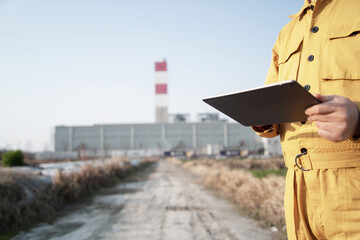 asian male engineer working  with digital tablet in oil refinery