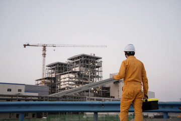 asian male engineer working  with digital tablet in oil refinery