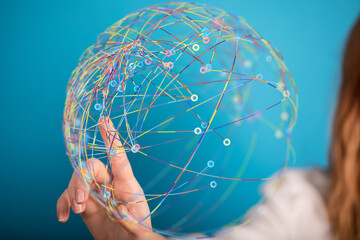 Abstract image of a hand interacting with a colorful global network sphere. Represents connection,...