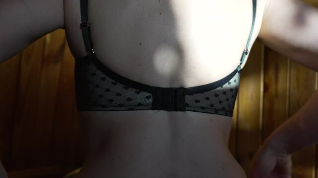 back bra woman Womans back wearing black patterned bra indoors