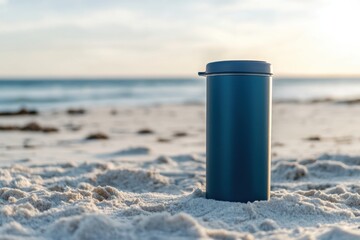 Beverage container resting on sandy beach during sunset near ocean waves