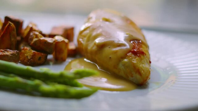 Elegant Dish of Pan Fried Chicken Fillet with Asparagus and Parmentier Potatoes with Creamy Peppercorn Sauce. High Quality Cooked Restaurant Food.