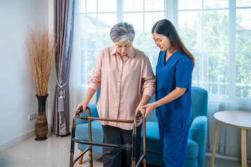 Nurse assisting senior woman with walker for rehabilitation at home