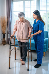 Senior Asian woman receiving rehabilitation support from nurse using walker at home