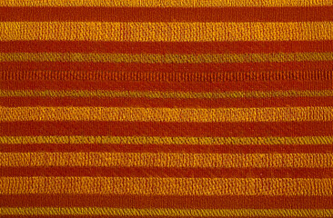 A striped wool fabric material closeup in red orange and yellow