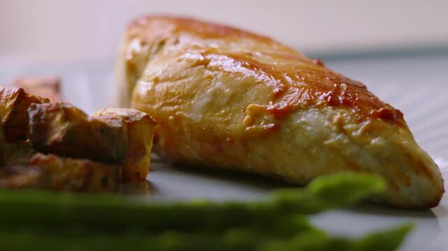 Slow Motion of Peppercorn Sauce Being Poured on Pan Fried Chicken Fillet with Asparagus and Parmentier Potatoes. High Quality Restaurant Food Footage.
