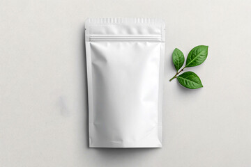 Blank white stand up pouch packaging mockup with green leaves
