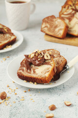 A piece of marble biscuit with chocolate cream and nuts	