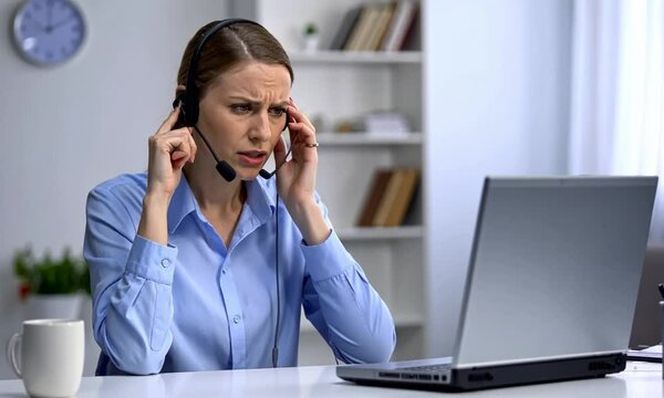Customer Service Representative Handling a Difficult Call with Frustrated Expression and On-Screen Notification Alerts

