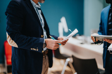Two professionals review paperwork together, symbolizing collaboration and teamwork in a business...