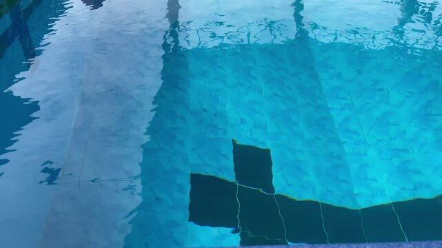Clean swimming pool water at the light-blue tiled floor background, stock footage