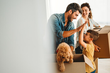Happy family with cardboard boxes in new house at moving day. Mortgage, family, real estate concept