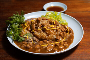 Chicken in brown gravy served with jasmine rice. Close-up of chicken in brown gravy over rice.