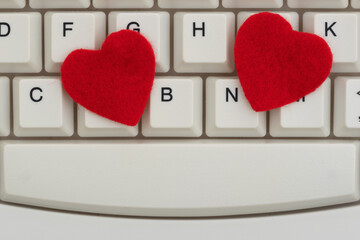 Close-up of white computer keyboard with two red hearts