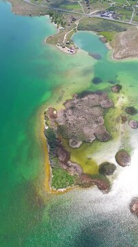 Scenic aerial drone image of a  island surrounded by white sand coastline. Chayei Island, Sevan, Armenia