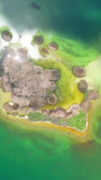 Scenic aerial drone image of a  island surrounded by white sand coastline. Chayei Island, Sevan, Armenia